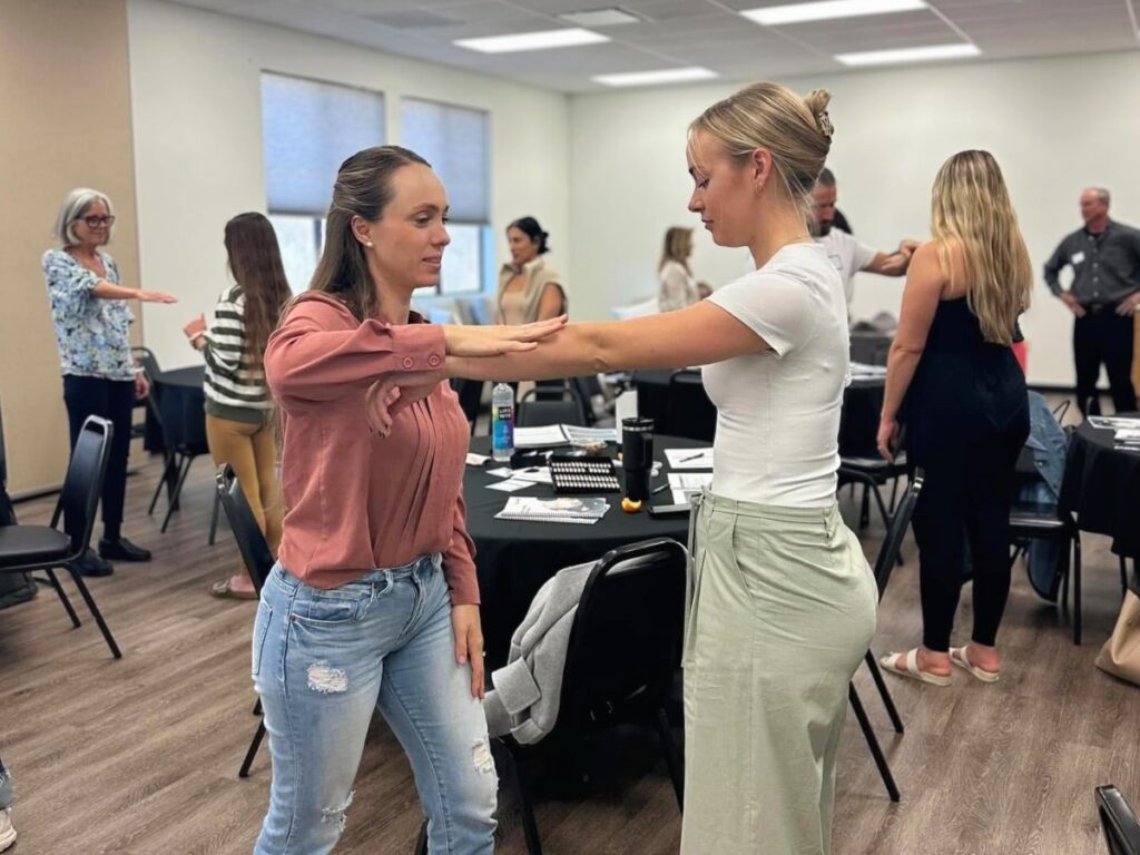 two young women practicing muscle testing