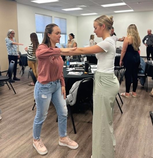 two young women practicing muscle testing